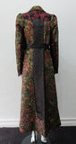 Belted Coat.  Full length multi-textured, multi-paneled coat in a variety of brocades in gold, brass, red & black. CF metal zipper concealed behind black satin trim.  4.5cm tie belt attached to coat at side seams. 59cm side hem slits.  Reverse pleats on front below waist for bit more ease. CB Coat length 131cm. Sleeve length from side neck point 78cm. 48% Acetate, 32% Cotton, 10% Viscose, 10% Lurex. Contrast: 65% Cotton, 35% Polyester. Lining 100% Rayon. Dry Clean Only. Made in England