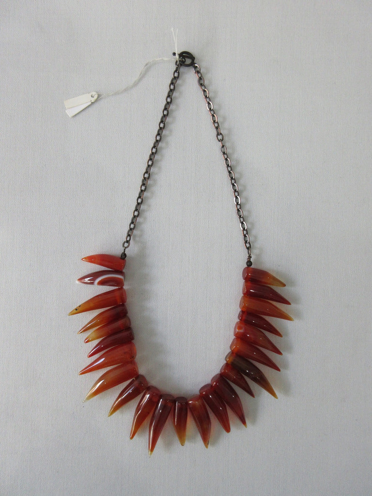 Tiger tooth pointed crystals in deep and blood orange colours. Smooth texture.