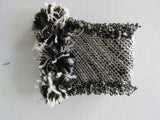Black & White Tweed style weave, with frayed detail on edge, 100% wool with 100% Cotton inner back lining.  Snap Closure. Size M -17cm from snap to snap width Size L -18cm from snap to snap width. 60g approximate weight, comes in white box. Made in France