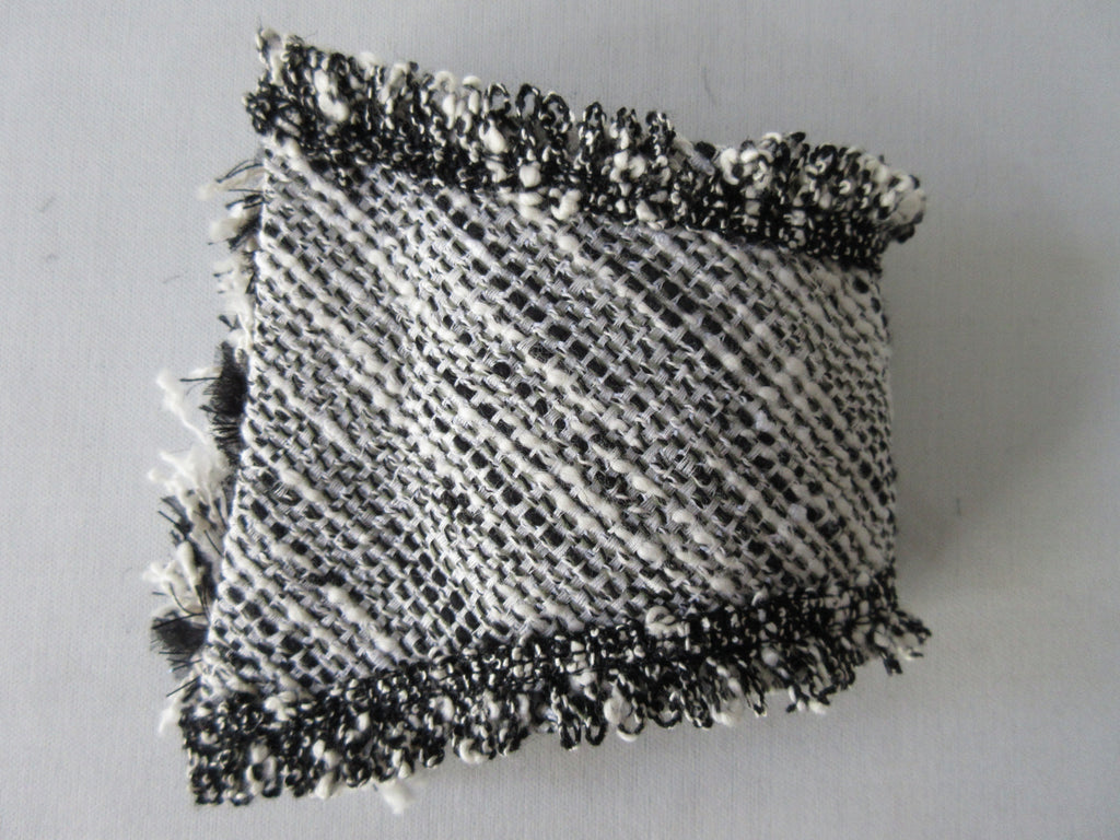 Black & White Tweed style weave, with frayed detail on edge, 100% wool with 100% Cotton inner back lining.  Snap Closure. Size M -17cm from snap to snap width Size L -18cm from snap to snap width. 60g approximate weight, comes in white box. Made in France