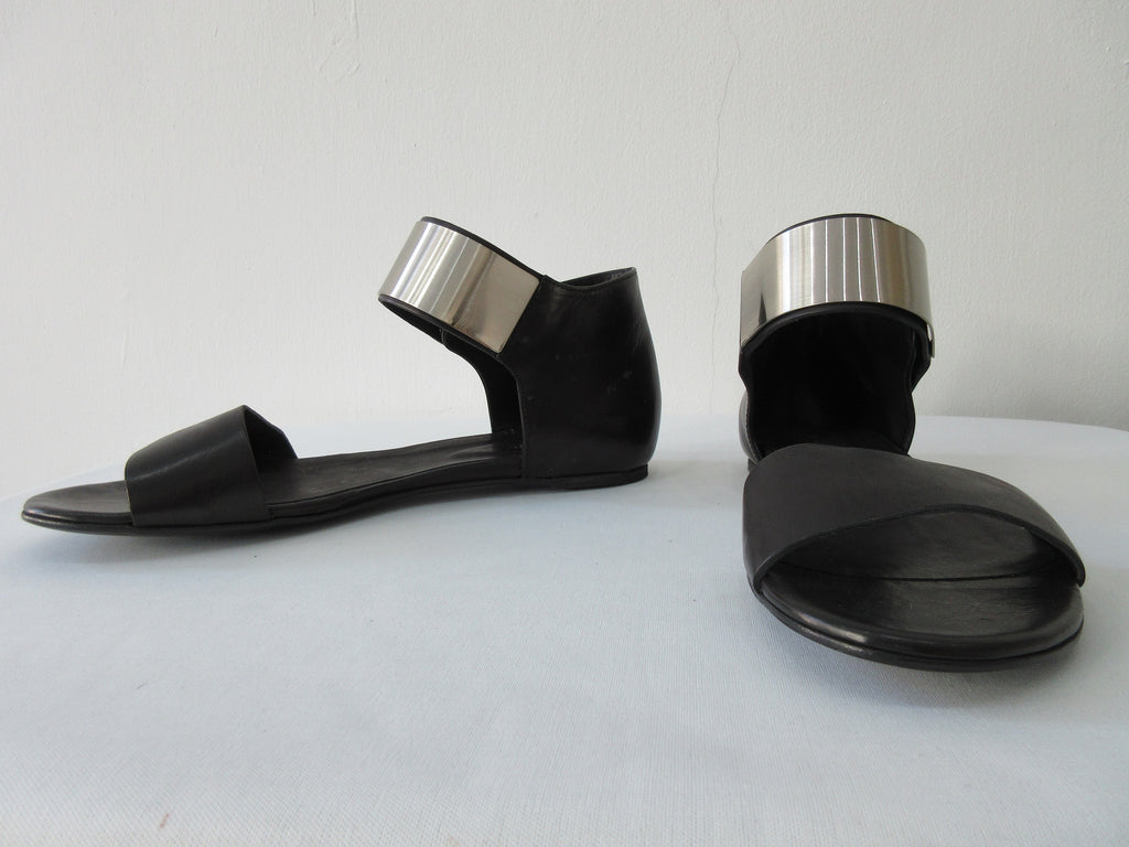 Vic Matie Flt Heel Metal Shin Shoe. Product Number: Vic Mate 1L5460D.L86L550101 Sandalo Alcazar 101 Black, 100% Leather with Stainless Steel Piece. Made in Italy